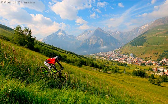 Mountain biker on the slopes above Les deux Alpes village in the summer